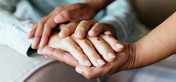 two pairs of hands intertwined indicating care and support